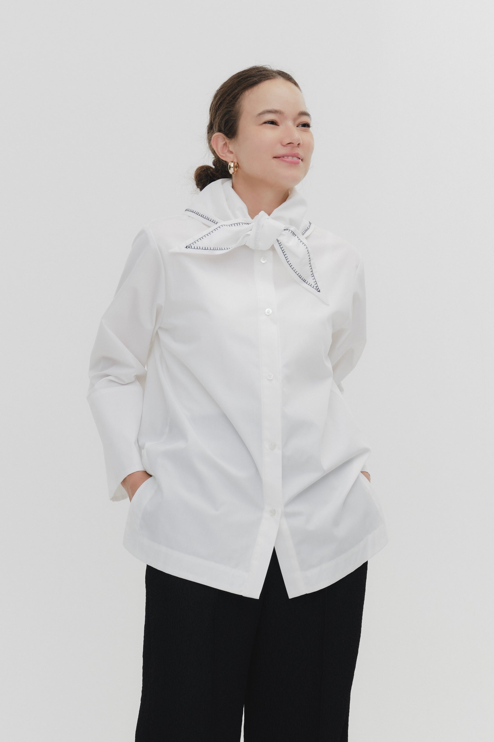 Model wearing white Sailor Ribbon Shirt with distinctive marine collar and decorative stitching details.